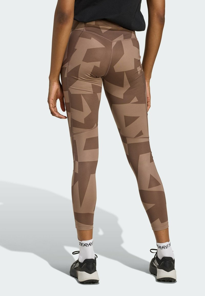 Leggings marroni con motivo geometrico caratterizzati da diverse sfumature di marrone. Realizzati in un materiale elasticizzato, ideali per l'abbigliamento sportivo.
