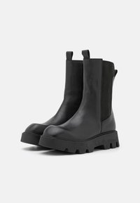 Black leather ankle boots with a chunky sole, elastic side panels, and pull tabs for easy wear. Smooth texture with solid construction.