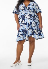 Květinové zavinovací šaty v námořnické modři s bledě modrými a bílými vzory, s krátkými rukávy, volánkovou sukní a vázáním v pase.