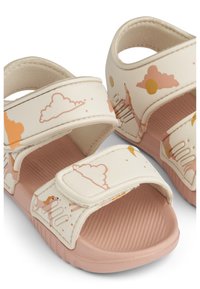 Lightweight sandals in cream with pink accents, featuring a textured sole, adjustable straps, and cloud and sun patterns.