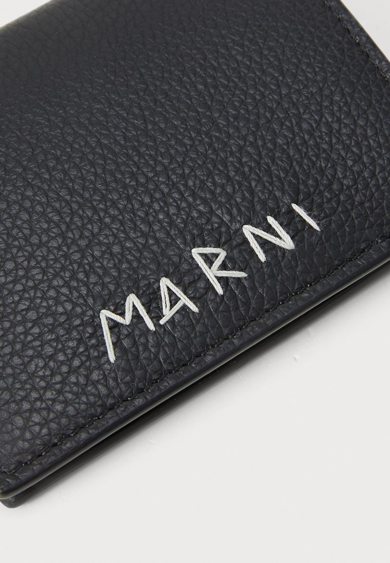 Schwarzes Lederportemonnaie mit strukturiertem Oberflächen, das das geprägte "MARNI"-Logo in weißem Faden entlang der Kante zeigt. Kompaktes und elegantes Design.