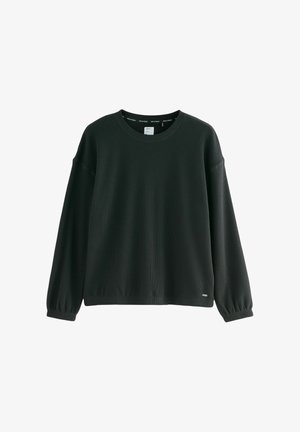 Mustast soonest särk ümarate kaelustega, pikkade balloonvarrukatega ja laia lõikega. Omab väikest logo tähist hemmi lähedal.