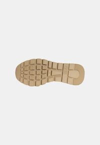 Sole di scarpa in gomma di colore sabbia, con un motivo testurizzato che presenta impugnature rettangolari e circolari per una migliore aderenza. Contrassegnata con il numero di modello “37.”