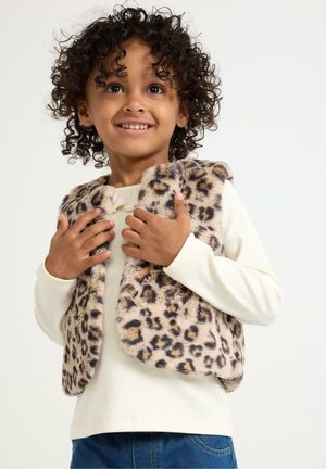 Leopardenmuster-Weste aus Kunstfell mit rundem Design, weicher Textur und ohne Verschlüsse, getragen über einem cremefarbenen Langarmshirt und blauen Jeans.