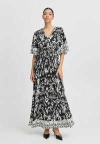Maxikleid in Schwarz und Weiß mit Wickeldesign, kurzen Ärmeln, Kordelzug in der Taille und komplizierten Mustern am Saum.