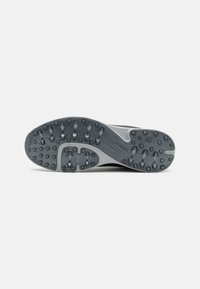 Gray athletic shoe sole featuring a textured pattern, circular and elongated studs for traction, and a smooth heel section.