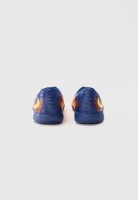 Blauwe sportschoenen met een gestructureerde synthetische bovenkant, met oranje en gele accenten op de hak en een afgeronde teenontwerp.