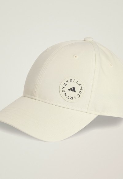 White baseball cap made of polyester with a curved visor, featuring a round logo patch in black on the left side. Smooth texture.