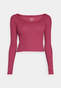 Fuchsiový cropped top s dlouhým rukávem, žebrovaný, s výstřihem do lodičky, přiléhavý střih a značka Hollister na štítku uvnitř límce.