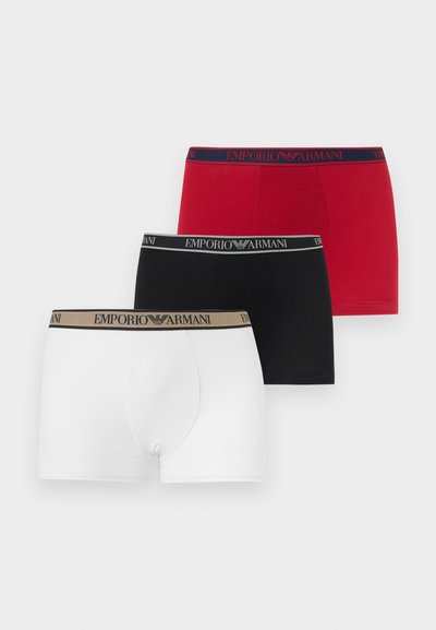 Három pár férfi Emporio Armani boxeralsó fehér, fekete és piros színekben, mindegyikük márkázott, összehangolt színű derékpánttal.