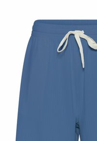 Plave kratke hlače s teksturiranim rebrastim dizajnom, koje imaju bijelu vezicu na pojasu. Materijal izgleda lagano i glatko.