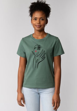 Groene katoenen T-shirt met een zwarte lijntekening van een hand met een bloem en een hart. Ronde hals en korte mouwen, casual pasvorm.
