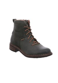 Botín de tobillo de cuero verde oscuro con cordones marrones, cuello de pelo sintético y una suela de madera marrón resistente. Acentos de costura a lo largo del borde.