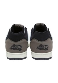 Sorte og grå sneakers med en glat tekstur, udstyret med en hvid gummisål og logo detaljer på hælen, designet i en lav-top silhuet.