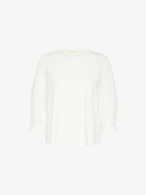 Bijela košulja s kratkim rukavima s jedinstvenim tijelom i teksturiranim, izvezenim čipkastim puf rukavima. Ima okrugli izrez i nabrane manžete rukava.