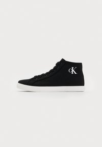 Sneaker montante en toile noire avec semelle en caoutchouc blanche et logo "cK" sur la cheville extérieure, présenté en profil latéral sur un fond blanc.