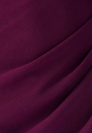 Paars gestructureerde stof met zachte plooien, die een glad materiaal en subtiele glans toont, ideaal voor kleding of accessoires.