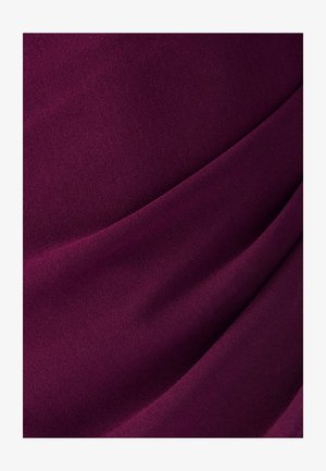 Tissu texturé violet avec un drapé doux, présentant un matériau lisse et une légère brillance, idéal pour les vêtements ou les accessoires.