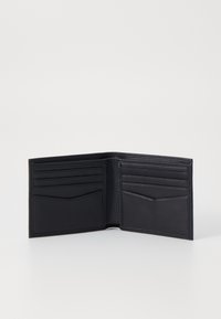 Portefeuille en cuir noir avec plusieurs emplacements pour cartes et une texture lisse. Design plié avec des coutures discrètes et un marquage sur un côté.