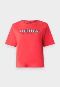 Piros rövid ujjú póló, melynek mellrészén fehér és tengerészkék "tommy JEANS" logó hímzett, környakú kivitelben.