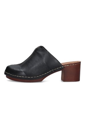 Zoccolo slip-on in pelle nera con tacco a blocco in legno cuoio e cuciture bianche visibili lungo il bordo della suola.