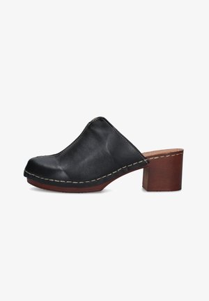 Zoccolo slip-on in pelle nera con tacco a blocco in legno cuoio e cuciture bianche visibili lungo il bordo della suola.