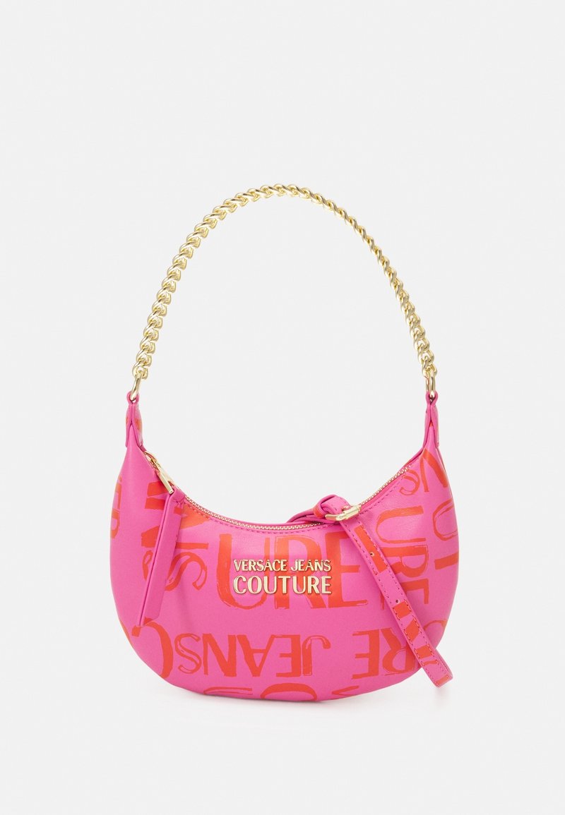 Bolso de mano rosa con forma curva, acabado brillante y correa de cadena dorada. Cuenta con letras en relieve de color naranja y cierre de cremallera.