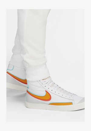 Hochschnitt-Sneaker aus weißem Leder mit orangefarbenen, roten und türkisfarbenen Akzenten; ausgestattet mit dicken Schnürsenkeln, einem gepolsterten Kragen und einer strukturierten Sohle.