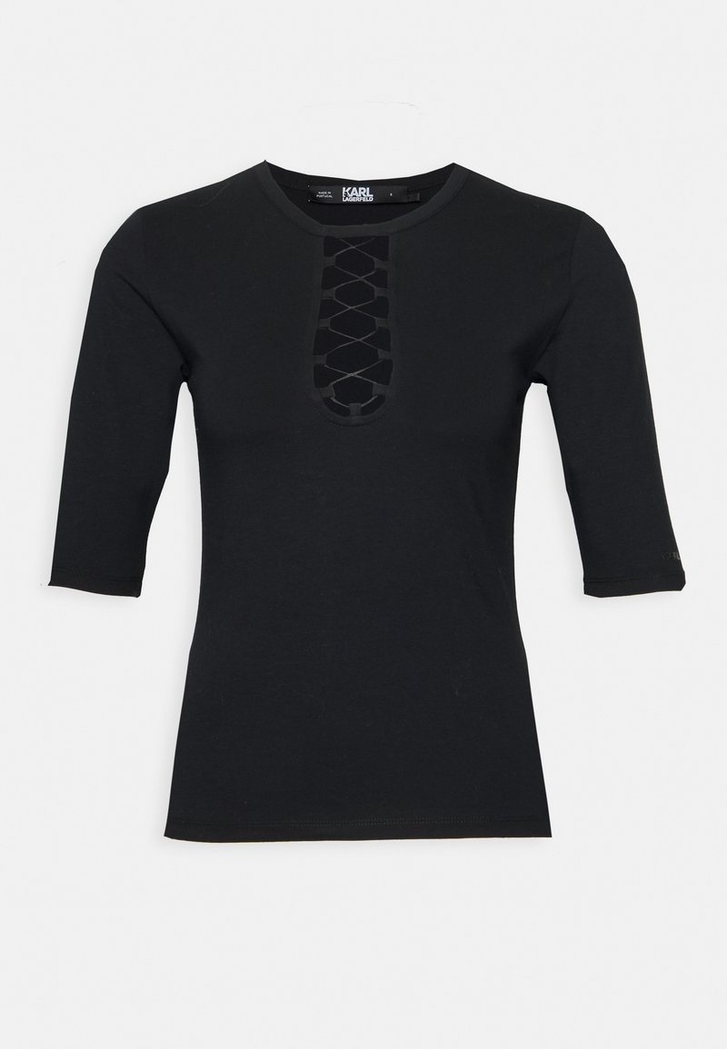 Černý přiléhavý top s tříčtvrtečními rukávy, s proplétaným šněrováním vpředu na výstřihu.