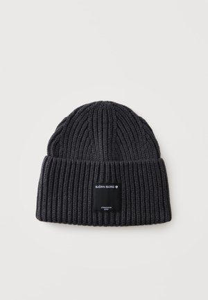 Bonnet en maille côtelée noire avec bord replié et étiquette rectangulaire noire affichant les textes "Björn Borg" et "Stockholm 1956".