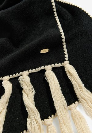 Musta sall, mis on valmistatud pehmest materjalist, omab elevandiluust ääriseid, dekoratiivset tikkimist ja väikest kuldset logo plaati brändi embleemiga.