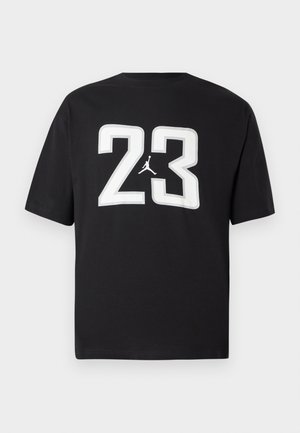 Čierne bavlnené tričko s krátkym rukávom, ktoré na prednej strane zdobí veľké biele číslo "23" a logo Jumpman; klasický dizajn okrúhleho výstrihu.