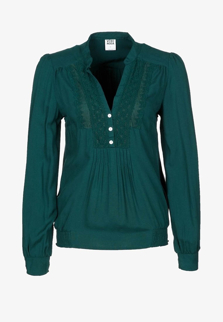 Blouse à manches longues vert foncé avec panneaux en dentelle, trois boutons blancs, tissu froncé sous les boutons et poignets et ourlet élastiqués.