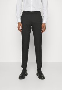 Fekete, slim fit szabású nadrág, lapos elejű, övhurkokkal és sima textúrával. Fekete formális cipővel párosítva.