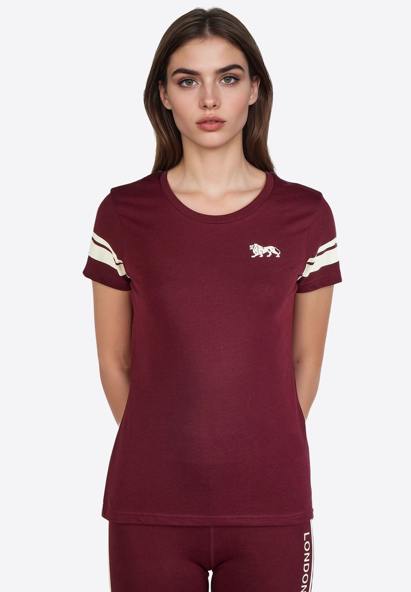 Camiseta burdeos de algodón suave con escote redondo, mangas cortas y acentos de rayas blancas en las mangas. Presenta un logo de león en el pecho.