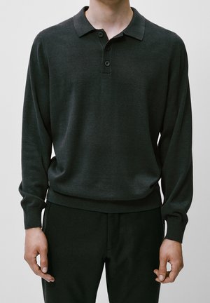 Dunkelgrünes Langarm-Poloshirt mit Kragen, Drei-Knopf-Leiste und gerippten Bündchen, kombiniert mit passenden schwarzen Hosen.