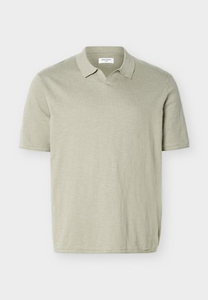 Lysebeige kortærmet poloshirt med en blød krave uden knapper, lavet af letvægtsstof.