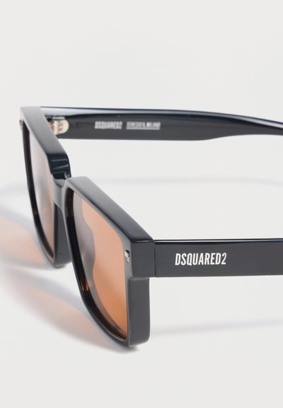 Μαύρα ορθογώνια γυαλιά ηλίου με φακούς καφέ απόχρωσης, με το λογότυπο "DSQUARED2" στο πλαϊνό μπράτσο.
