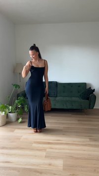 Μαύρο φόρεμα με λεπτές τιράντες και εφαρμοστή γραμμή, που διαθέτει λουλουδάτη λεπτομέρεια στον αριστερό ώμο. Συνδυάζεται με καφέ σανδάλια και τσάντα.