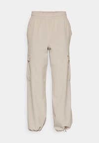 Pantaloni cargo beige realizzati in tessuto morbido, con vita elastica, polsini regolabili e tasche laterali per una maggiore praticità.