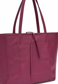 Borsa a tracolla fucsia in pelle con superficie texturizzata, due manici robusti e dettaglio di chiusura con cordoncino. Forma rettangolare e design minimal.