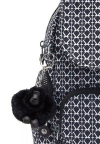 Schwarz-weißer Rucksack mit gemustertem Design und glatter Stoffoberfläche, ausgestattet mit einem runden Deckel, einem Reißverschlussfach und einem flauschigen schwarzen Affen-Schlüsselanhänger.