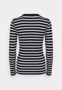 Top à manches longues, à rayures noir et blanc, avec un col rond. Le tissu semble doux et lisse, avec des rayures horizontales espacées de manière uniforme.