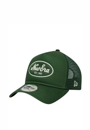 Casquette trucker réglable New Era vert foncé avec logo brodé blanc et panneau arrière en mesh sur fond blanc.