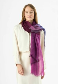 Écharpe en dégradé de violet en tissu léger, présentant une texture douce, des bords effilochés et des teintes variant du prune profond au lavande.