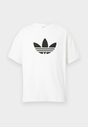 T-shirt bianco in cotone con un grande logo trefoil nero di Adidas e tre strisce orizzontali sotto. Maniche corte, scollo rotondo.