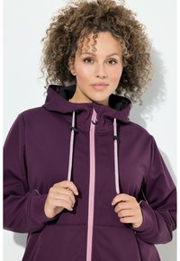 Purple softshell jacket with a zip front and pink accents, featuring a hood and adjustable drawstrings for a snug fit.