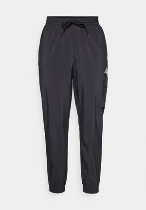 Pantaloni sportivi neri con vita elasticizzata e cordino, gambe affusolate, tasca laterale e dettagli logo sulla coscia sinistra.