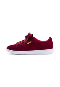 Low-top burgundy velvet Puma sneaker with satin ribbon laces, gold logo on side, and white rubber sole, viewed from the outer side.