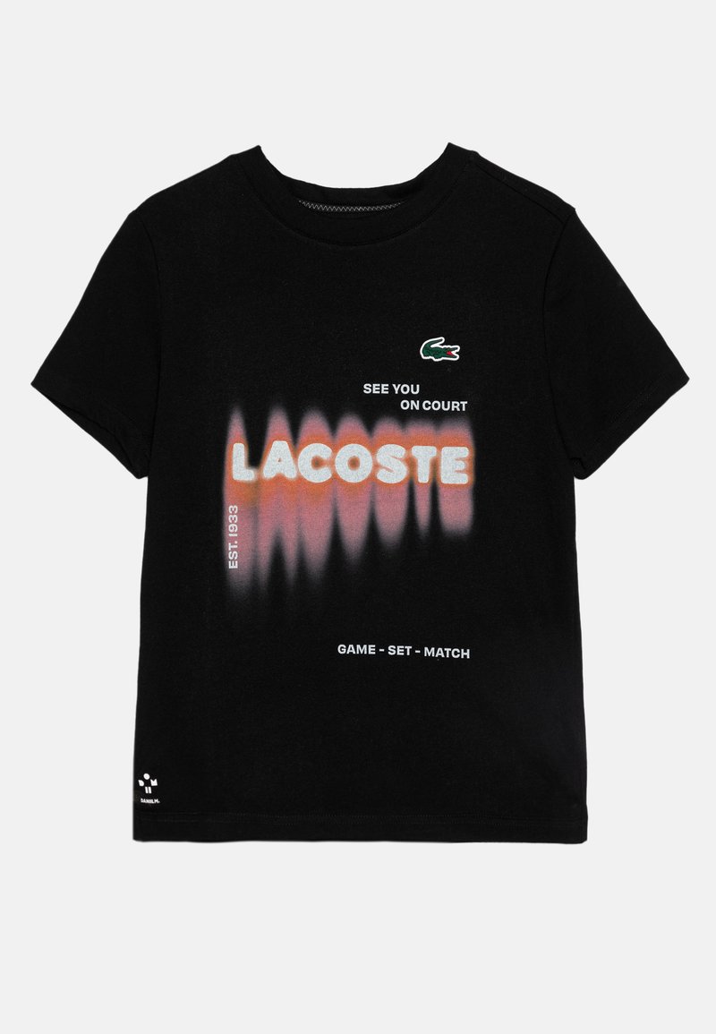 Czarny bawełniany t-shirt z napisem "LACOSTE" w gradientzie pomarańczowym i białym, z logo na piersi, okrągłym dekoltem i krótkimi rękawami.